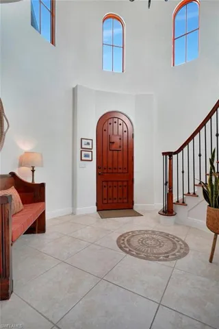 Entrance foyer with light tile patterned floors and a towering ceiling