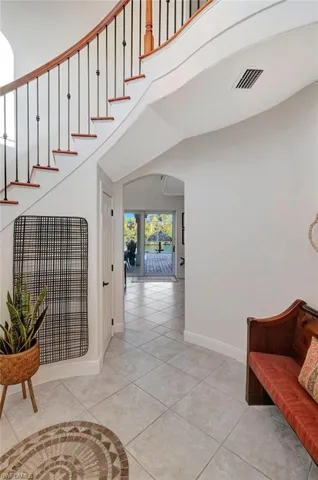 Stairs featuring tile patterned flooring and a high ceiling