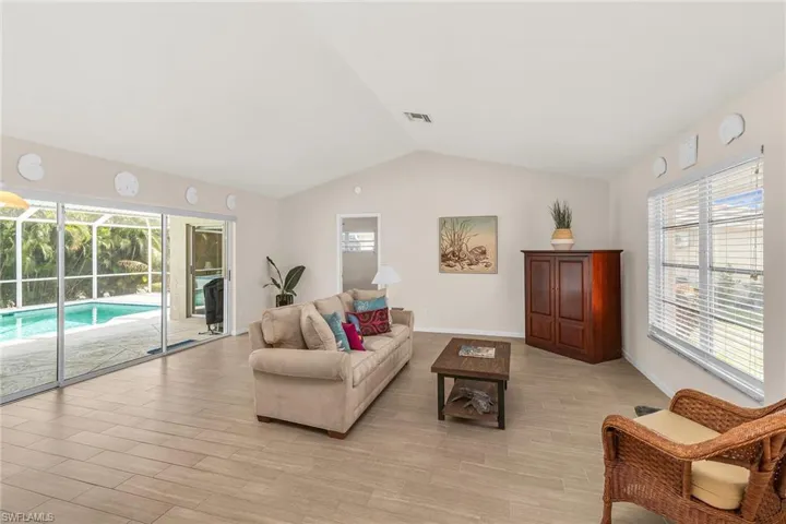 Living room featuring visible vents, a wealth of natural light, and lofted ceiling