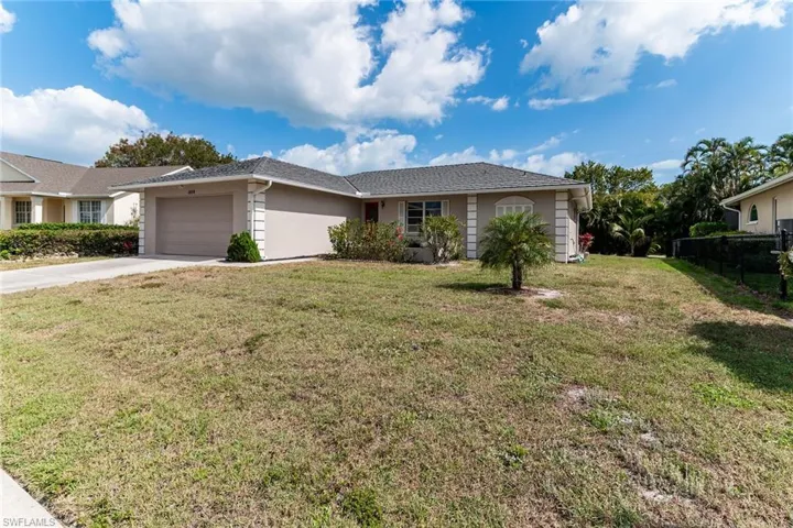 Ranch-style home with a front lawn, a garage, concrete driveway, stucco siding, and fence