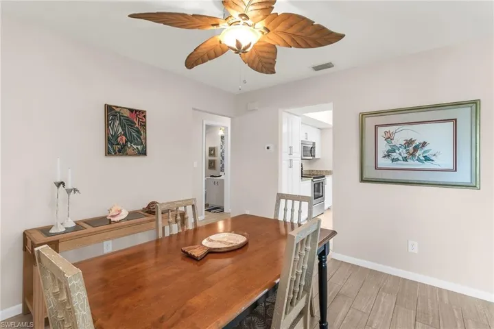 Dining room featuring visible vents, ceiling fan, light wood finished floors, and baseboards