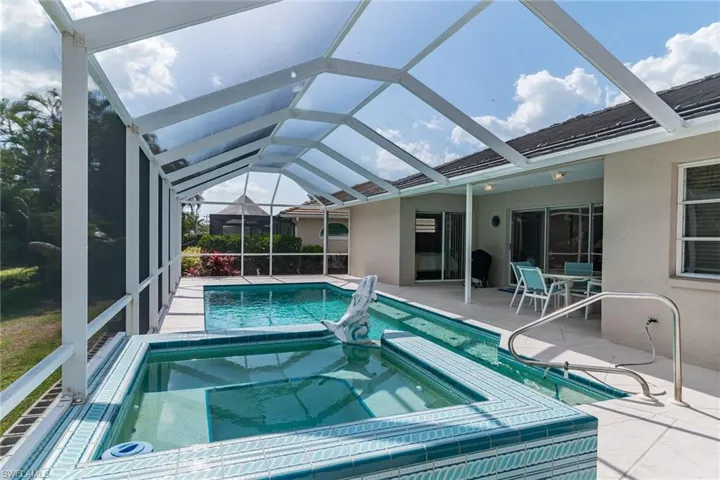 View of swimming pool with a lanai, a patio area, and a pool with connected hot tub