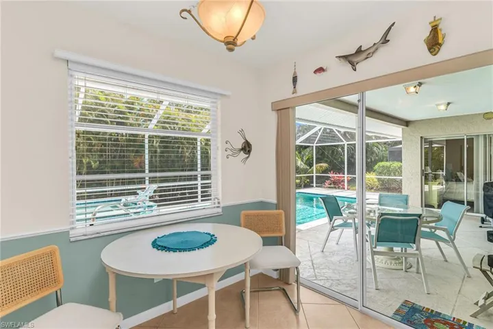 Dining space featuring tile patterned floors and a sunroom