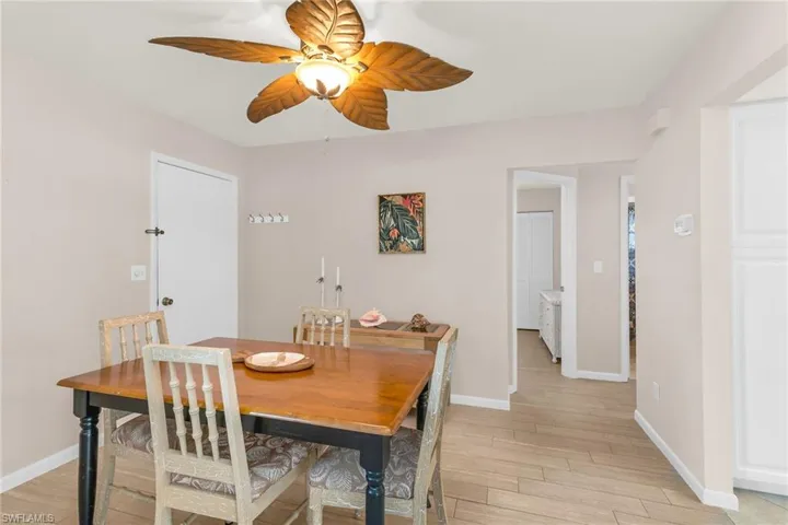 Dining room with ceiling fan, light wood finished floors, and baseboards