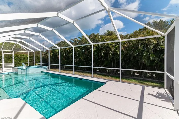 View of pool with a lanai, a patio area, and a pool with connected hot tub