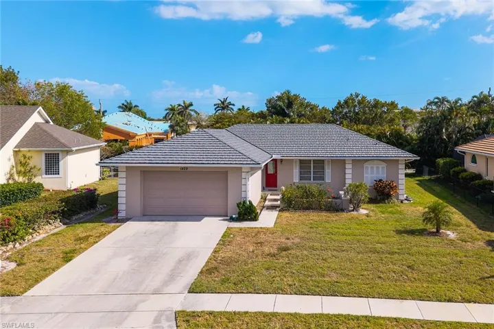 Ranch-style home with concrete driveway, a front lawn, an attached garage, and stucco siding