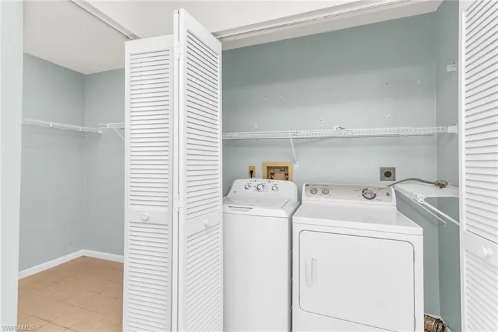 Washroom featuring baseboards, washing machine and clothes dryer, and laundry area