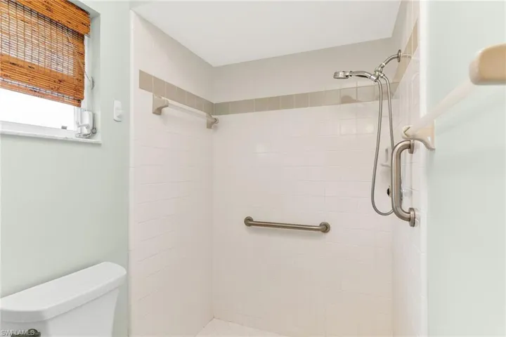 Full bath featuring toilet and a tile shower