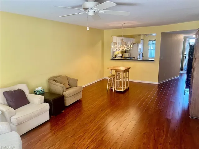 Living room with dark hardwood / wood-style floors and ceiling fan