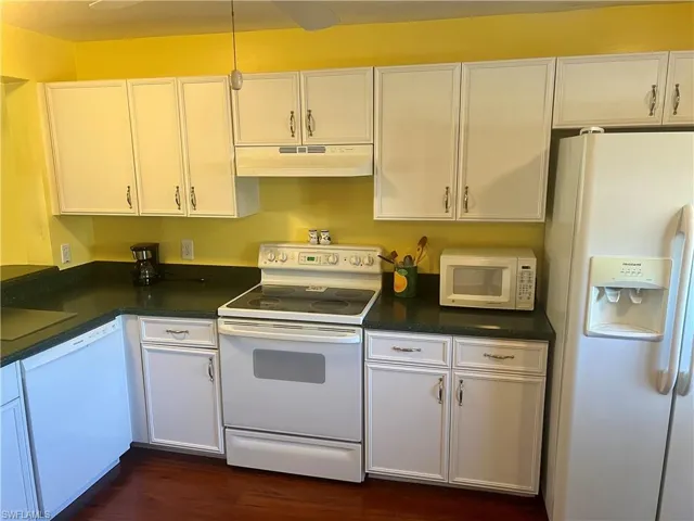 Kitchen featuring white cabinetry, white appliances, and dark wood-type flooring