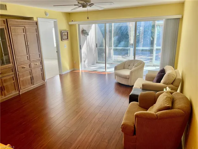 Living room with hardwood / wood-style flooring and ceiling fan
