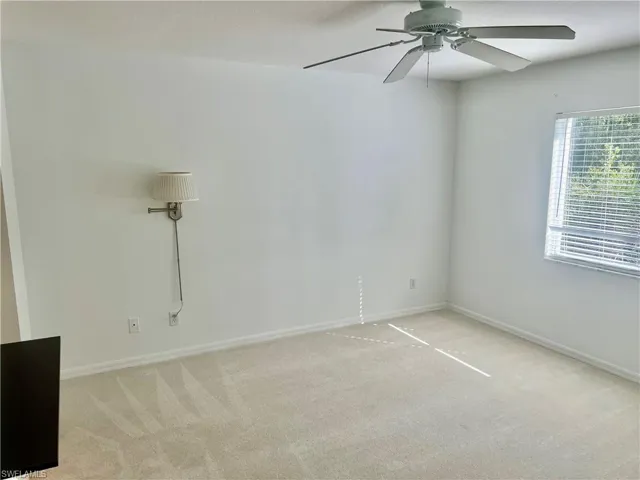 Carpeted spare room featuring ceiling fan