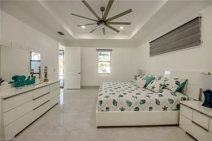 Bedroom featuring a raised ceiling and ceiling fan
