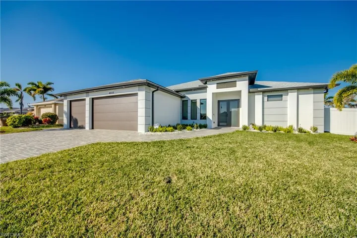 View of front of home with a garage and a front yard