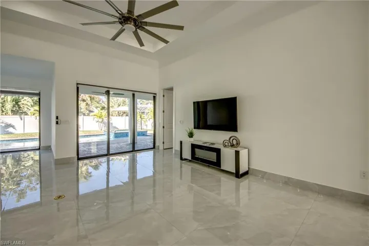 Unfurnished living room featuring a high ceiling and ceiling fan