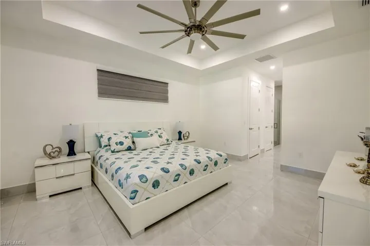 Bedroom featuring a tray ceiling and ceiling fan