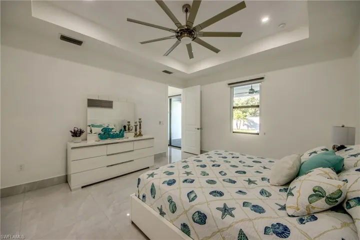 Bedroom featuring a raised ceiling and ceiling fan