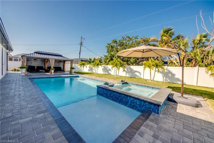 View of swimming pool featuring a gazebo, an in ground hot tub, and a patio area