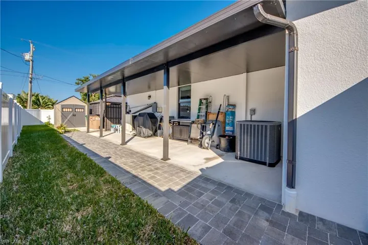 View of patio / terrace featuring central AC unit and a shed