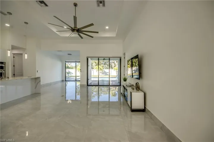 Spare room featuring a tray ceiling, ceiling fan, and a towering ceiling