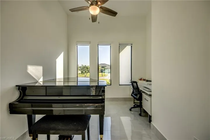 Misc room featuring built in desk and ceiling fan