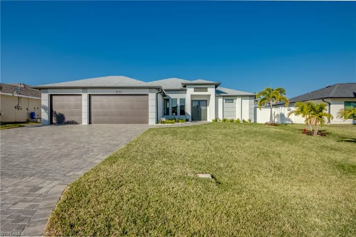 View of front of house with a garage and a front lawn