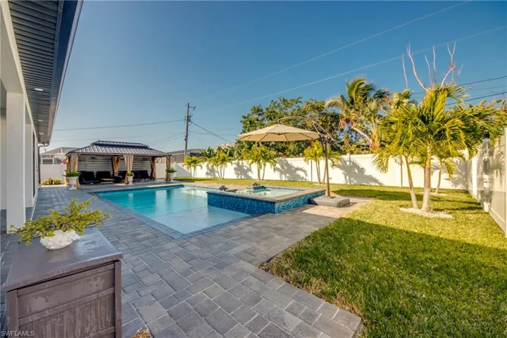 View of pool featuring a gazebo, an in ground hot tub, a patio area, and a lawn