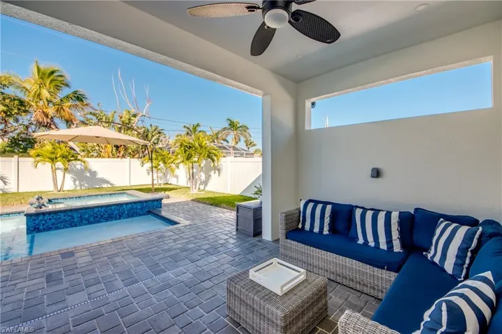 View of patio featuring an in ground hot tub, outdoor lounge area, and ceiling fan