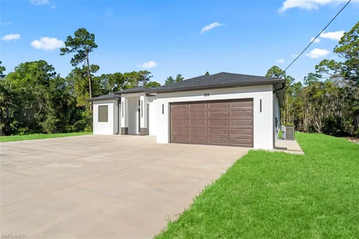 Modern exterior with a brown sectional garage door, white stucco facade, dark roof, and a concrete driveway