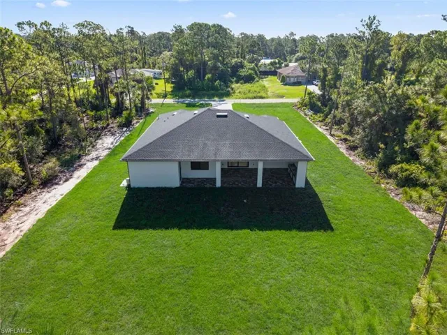 Newly constructed residence with a dark shingle roof and white exterior
