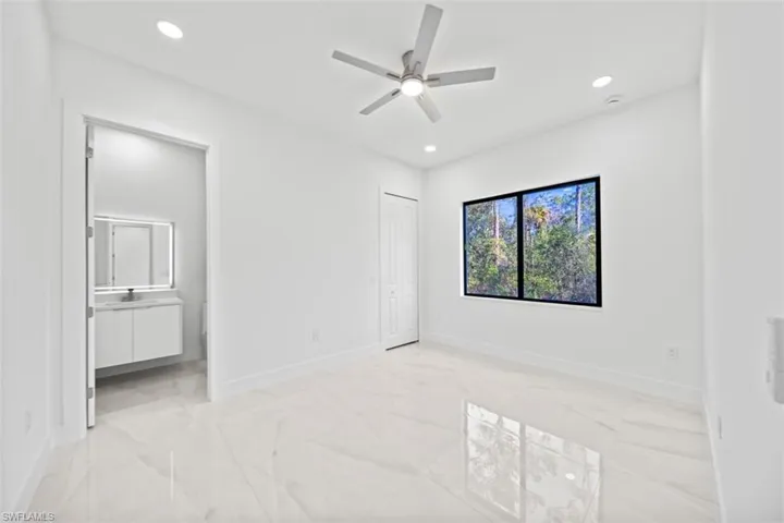 Bright room featuring white walls, large format tile flooring, a contemporary ceiling fan, recessed lighting, and a large window with black framing