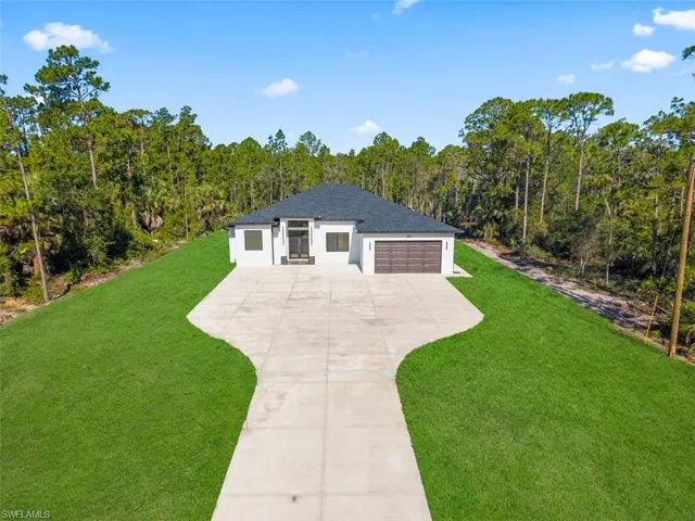 Contemporary single-story residence featuring a dark shingle roof and a light-colored stucco exterior