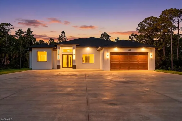 Contemporary white stucco exterior with a dark roof and integrated lighting