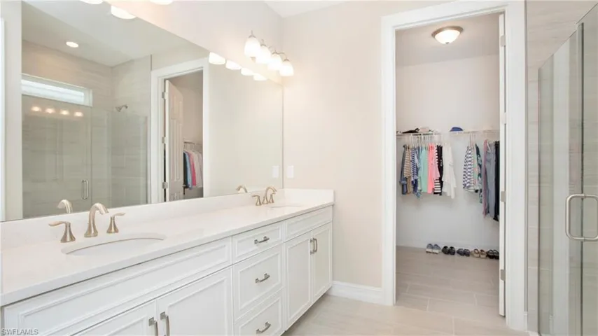 Main bedroom bathroom with vanity and a shower with door