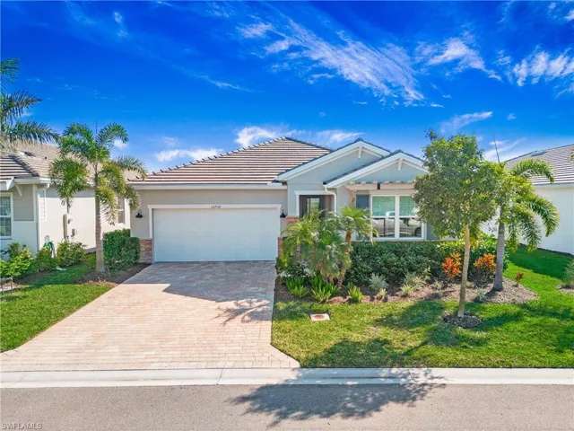 View of front facade featuring a front yard and a garage