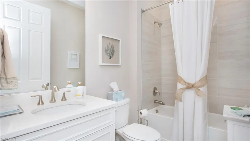 Full bathroom with shower / bath combination with curtain, vanity, and toilet