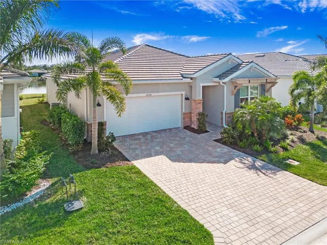 View of front of home featuring a front lawn, a garage, and a water view