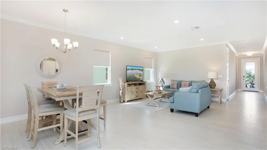 Dining space featuring ornamental molding, an inviting chandelier, and light hardwood / wood-style flooring