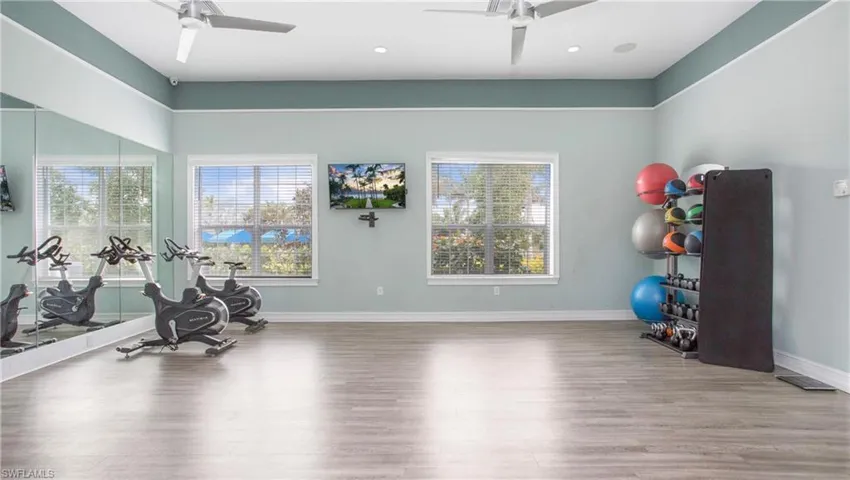 Community Exercise area featuring hardwood / wood-style flooring and ceiling fan