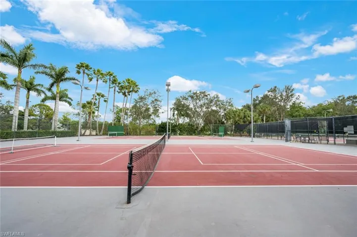 View of tennis court with community basketball court and fence