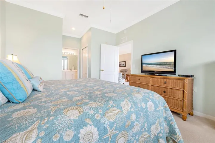 Bedroom featuring carpet, visible vents, ornamental molding, connected bathroom, and baseboards