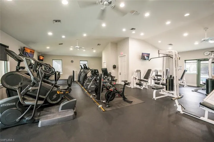 Workout area with a ceiling fan, lofted ceiling, visible vents, and recessed lighting