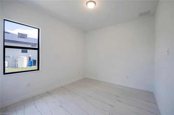Unfurnished room with baseboards and light marble finish flooring