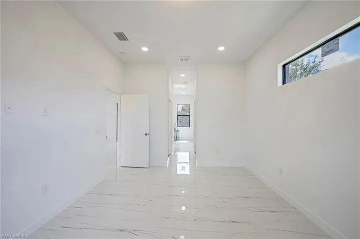 Empty room with recessed lighting and light marble finish flooring