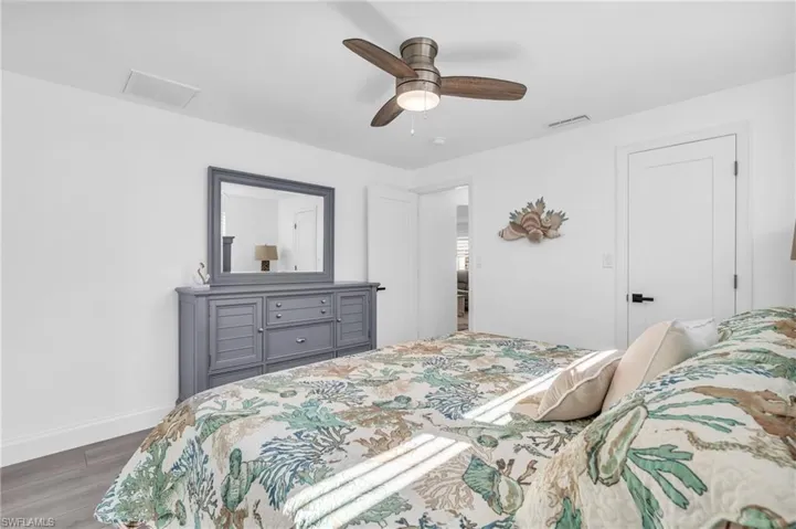 Bedroom with dark hardwood / wood-style flooring and ceiling fan - VIRTUALLY ENHANCED