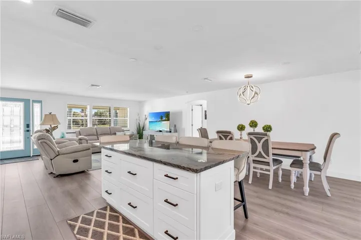 Kitchen island, pendant lighting, and dark stone counters - VIRTUALLY ENHANCED