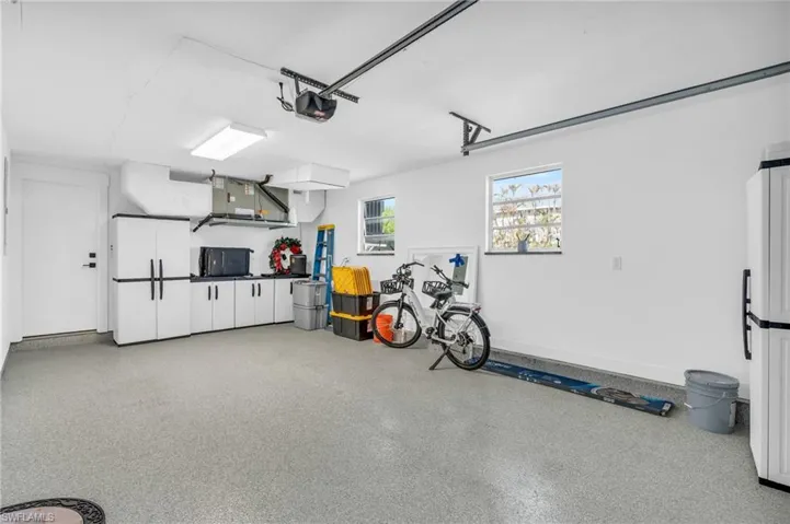 Garage featuring a new garage door and additional storage cabinets - VIRTUALLY ENHANCED