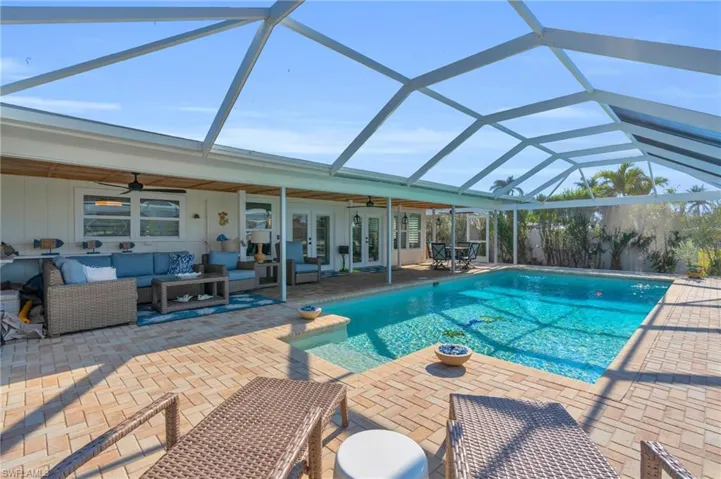 View of pool featuring new ceiling fans, and covered outdoor living space - VIRTUALLY ENHANCED