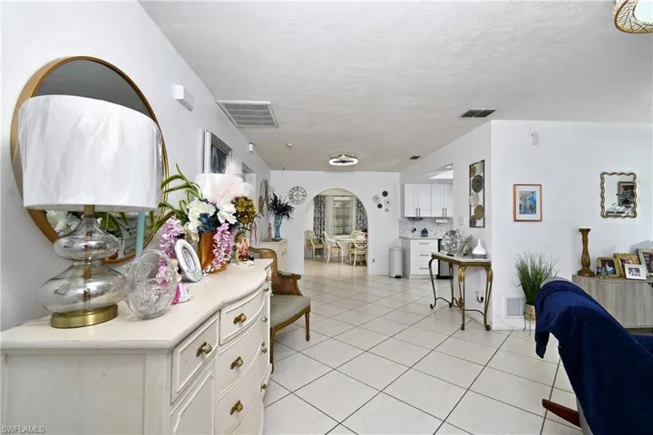 Hallway with light tile patterned floors and a textured ceiling