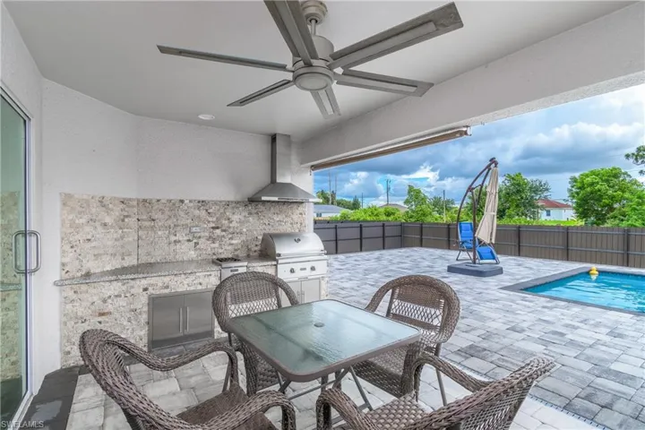 View of patio featuring ceiling fan, a grill, a fenced in pool, and area for grilling